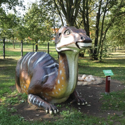 Iguanodon - widok całego zwierzęcia leżącego na trawie